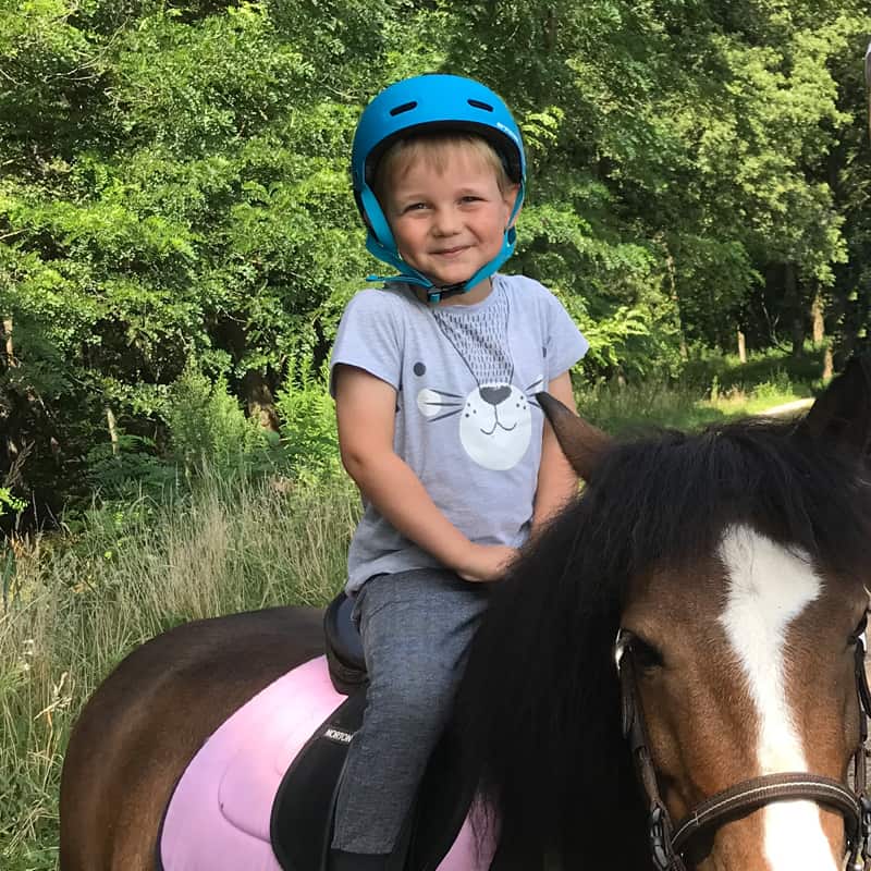Garçon qui fait balade à poney
